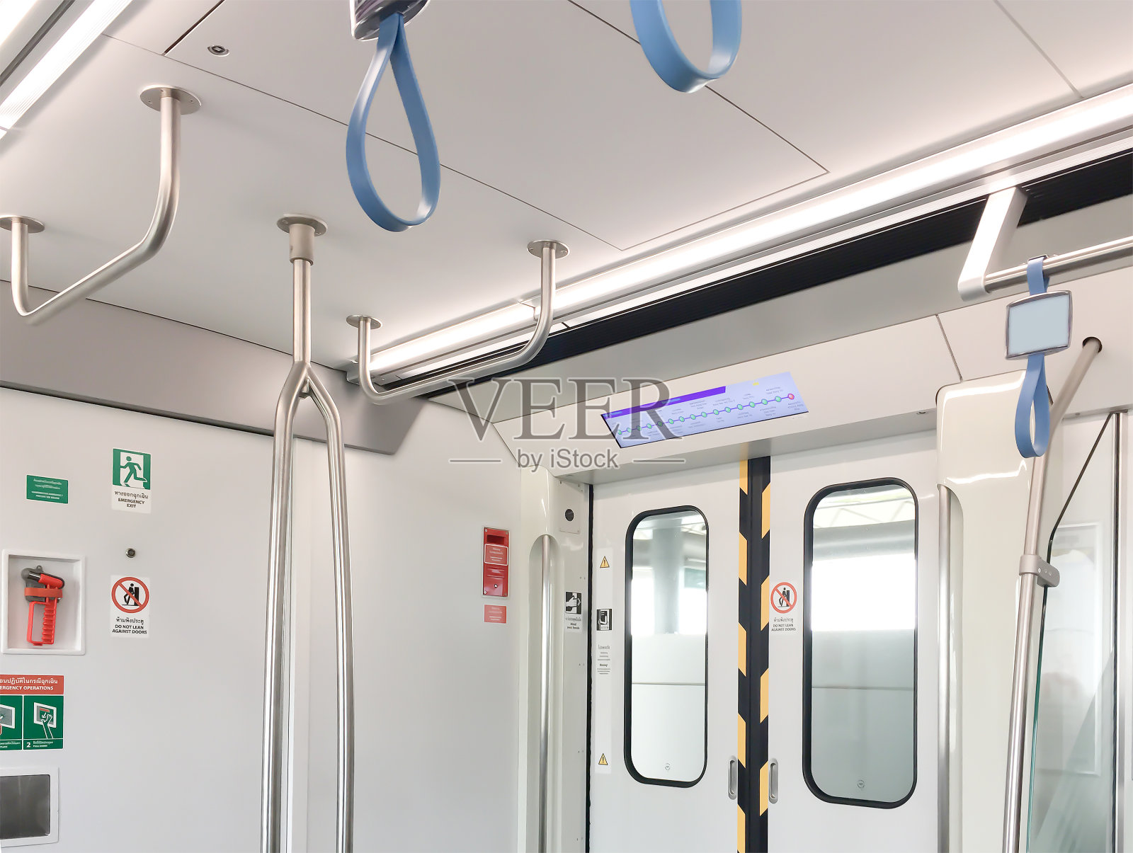 曼谷地铁内部车门处有安全标志和悬挂的钢条供人们使用。室内图像的背景使用。照片摄影图片