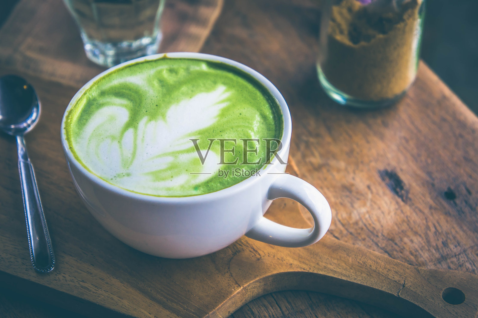 绿茶热饮拿铁白杯放在木桌上，香气馥郁，休闲时光在咖啡厅咖啡厅照片摄影图片