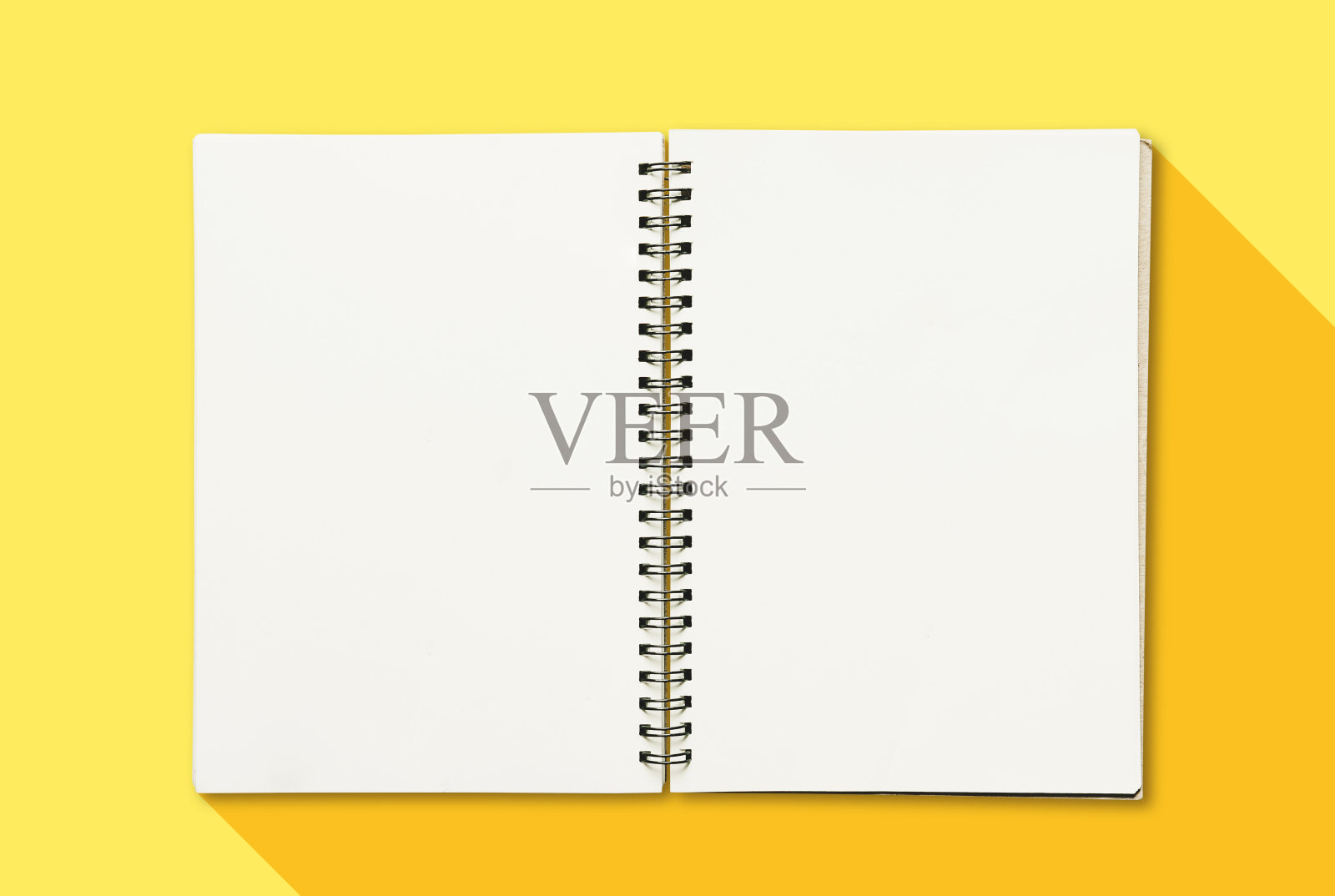 翻开一本黄色背景上空白白纸的书照片摄影图片