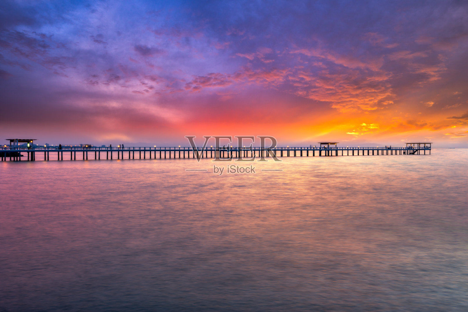 海上木桥日落的景象。木头桥照片摄影图片