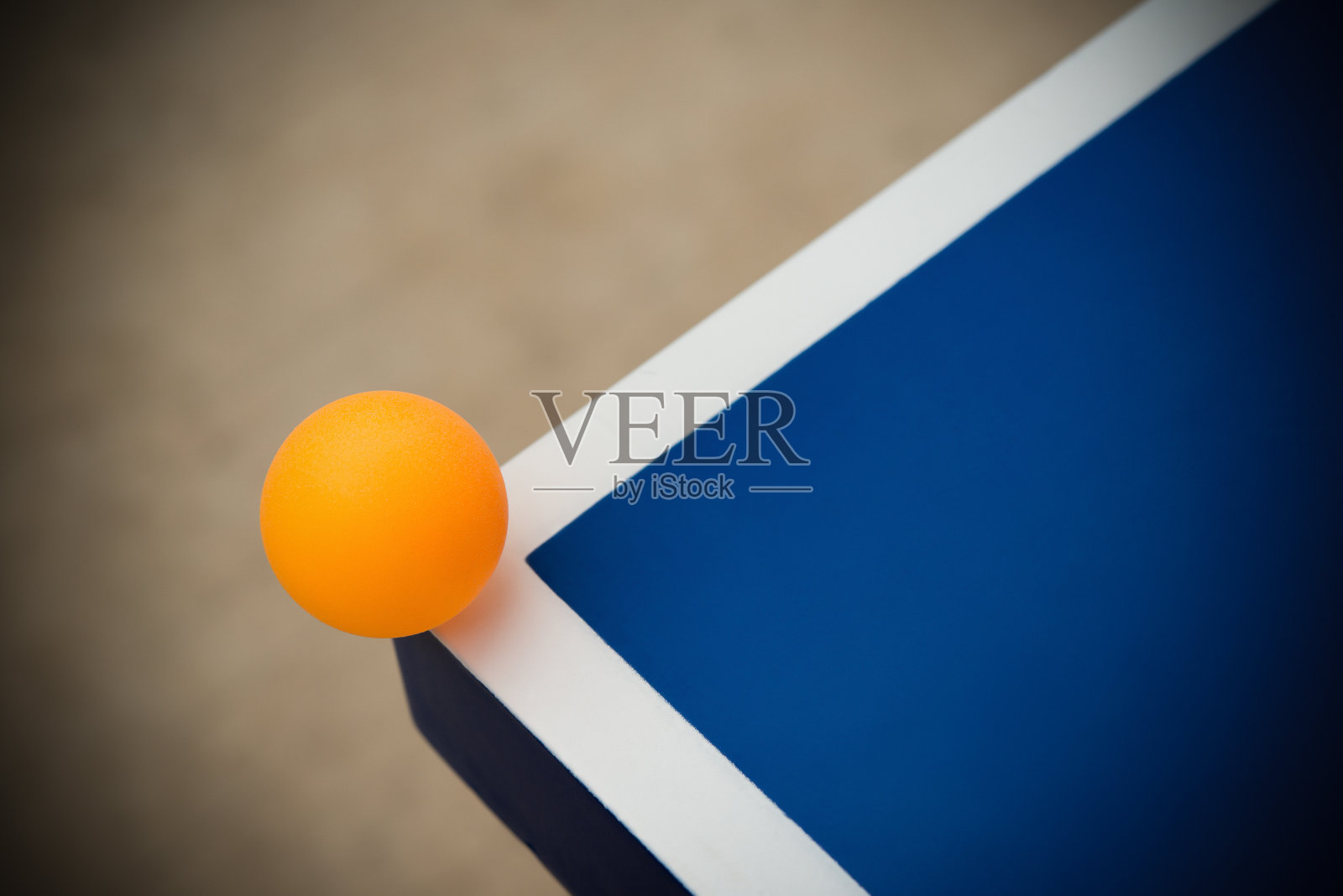 乒乓球打在蓝色乒乓球桌的一角照片摄影图片