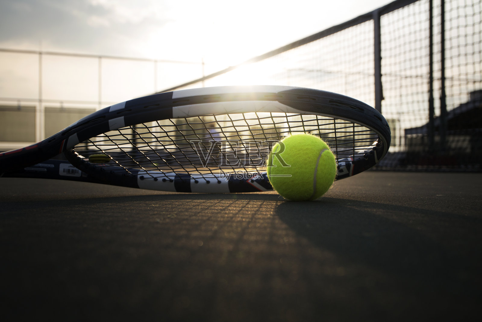 阳光下硬地上的网球和球拍照片摄影图片
