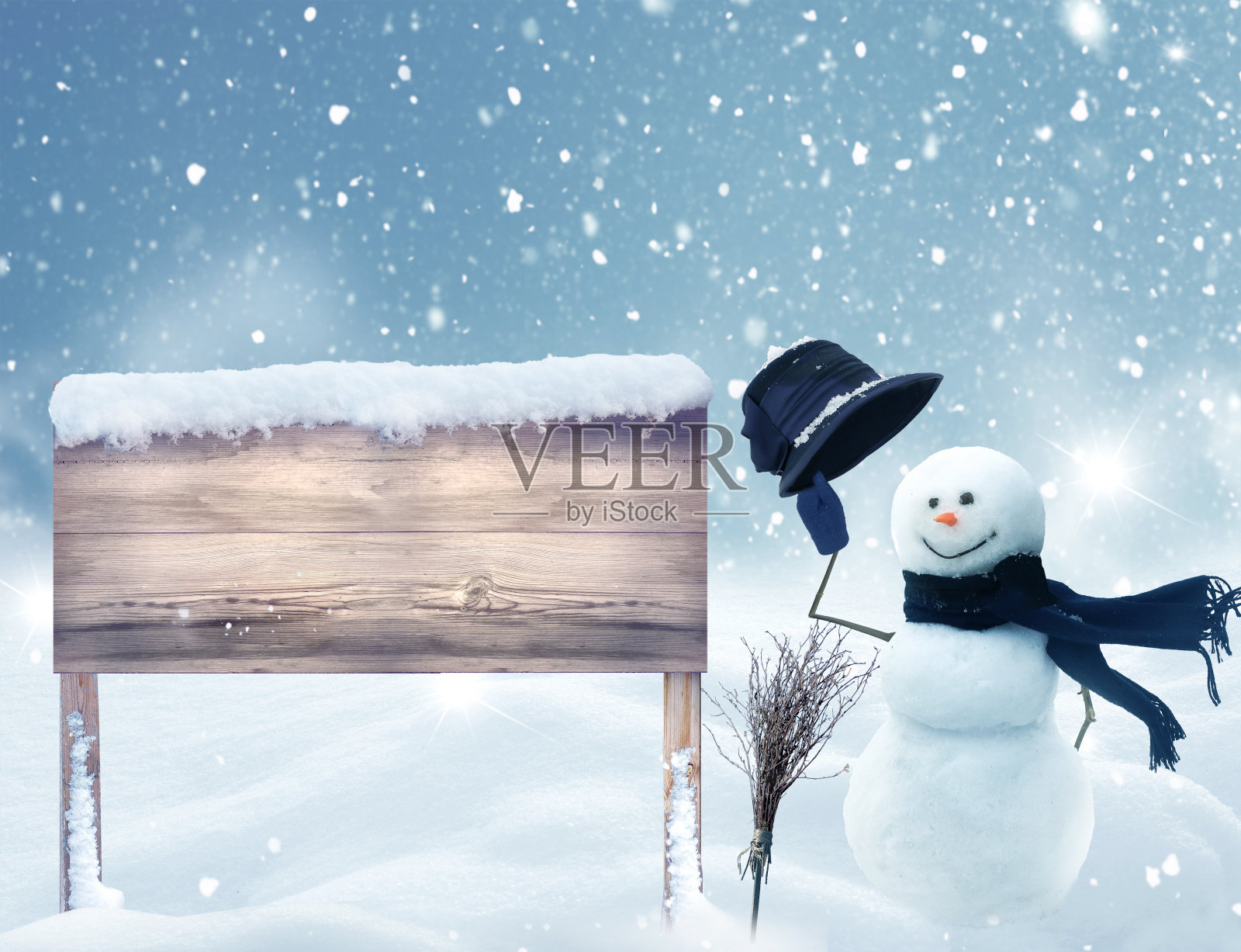 圣诞快乐，新年贺卡与木招牌在雪。雪人站在冬天的圣诞景观。冬天的背景照片摄影图片