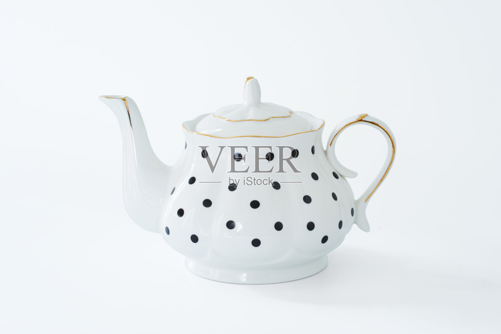 白色茶壶与黑点设计孤立在白色背景。照片摄影图片