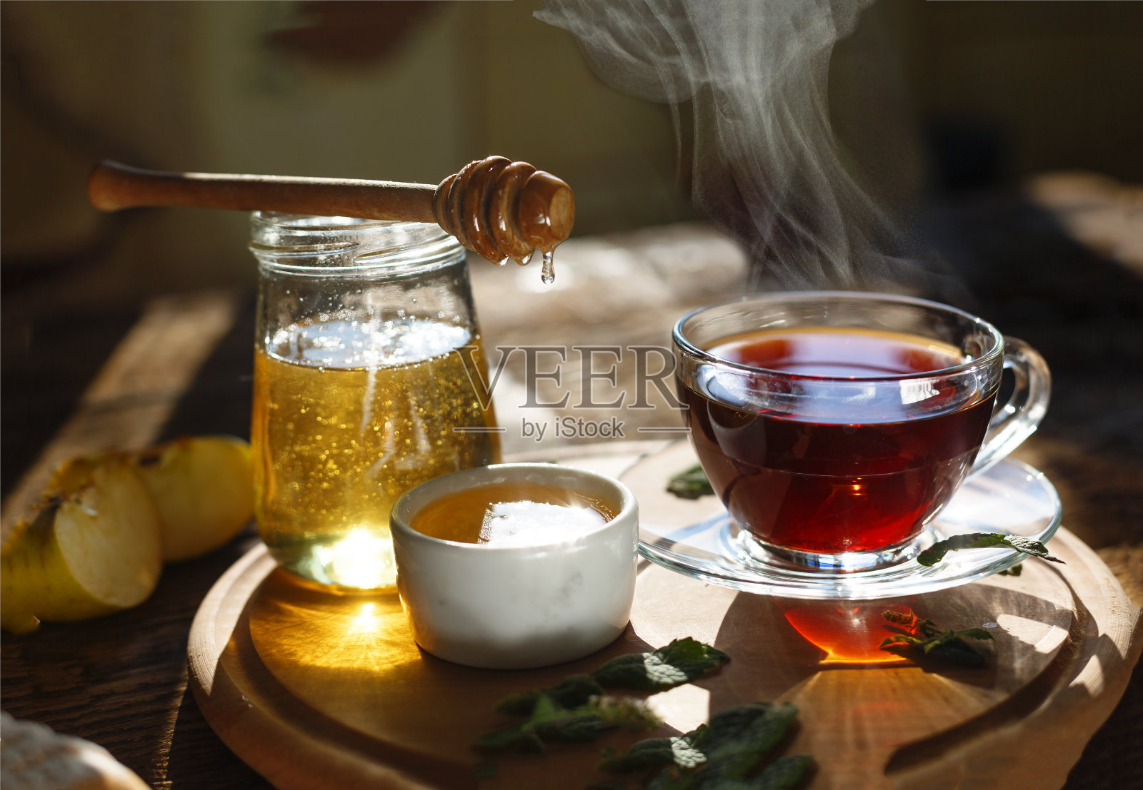 健康的早餐。茶喝。早上的时间。一杯红茶，蜂蜜，薄荷叶，苹果。照片摄影图片