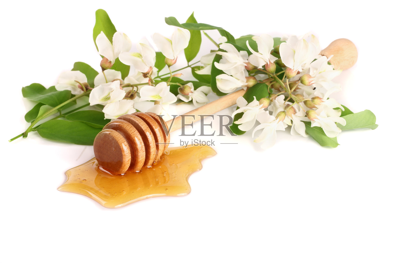 蜂蜜棒与流动的蜂蜜和金合欢花孤立在白色的背景照片摄影图片