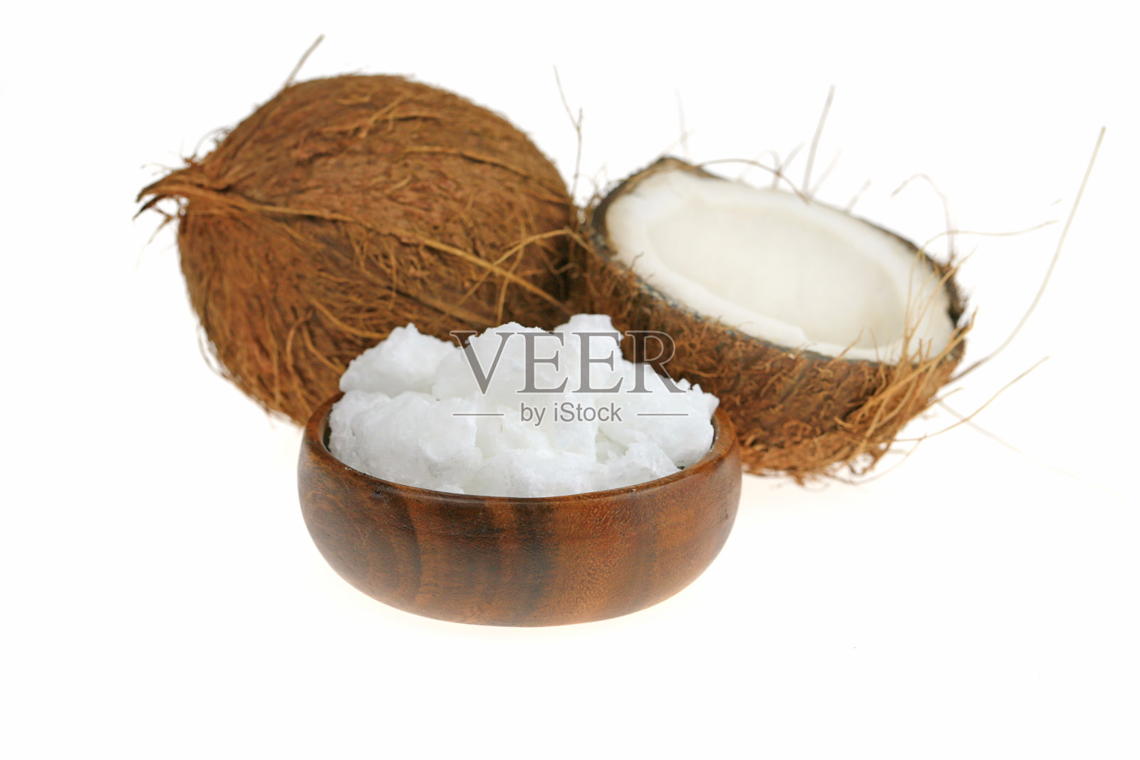 未经提炼的椰子油。椰子在一个切割和白色天然椰子油在棕色木制圆杯孤立在白色的背景照片摄影图片