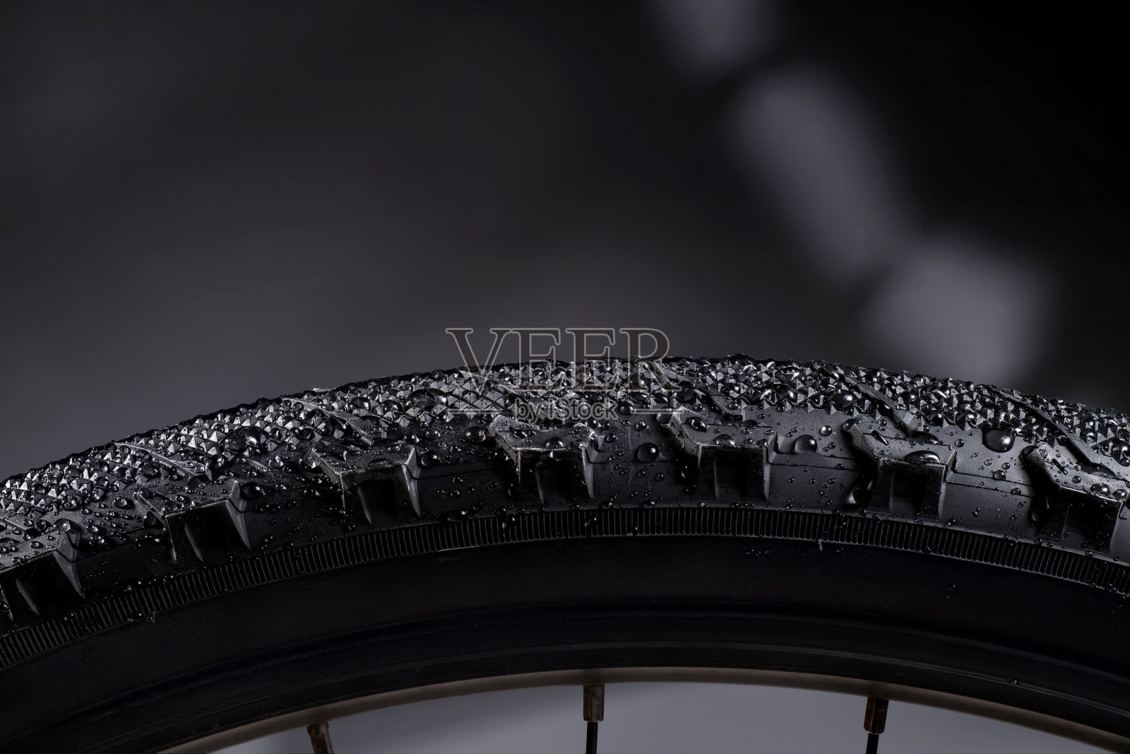 黑色自行车轮胎与水滴在抽象的背景。照片摄影图片