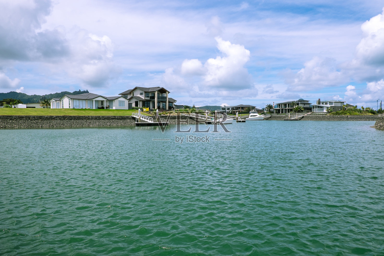 位于新西兰北岸旺阿雷附近的马斯登湾(Marsden Cove)的滨水房屋和私人码头照片摄影图片
