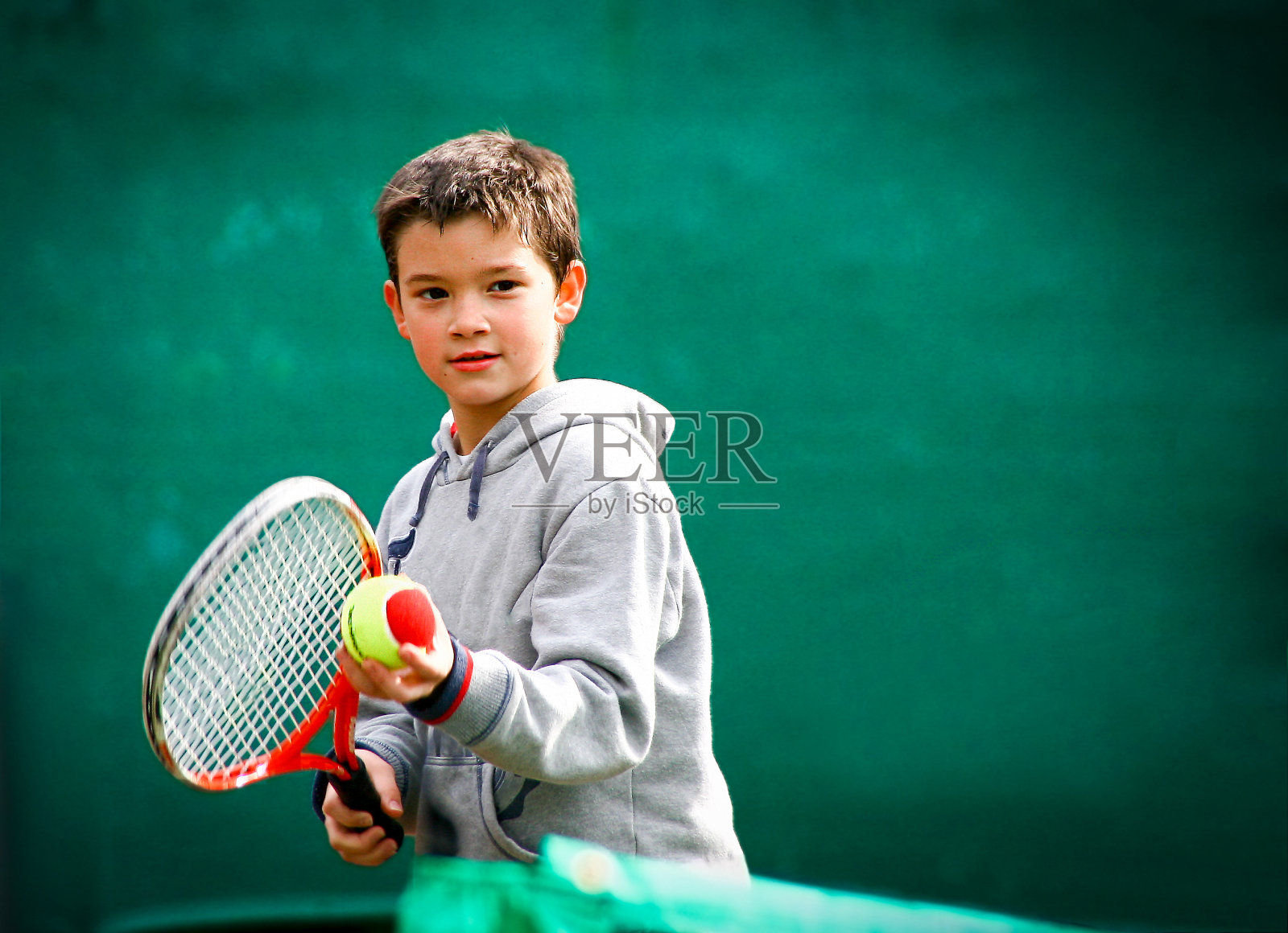 模糊的绿色背景上的小网球选手照片摄影图片