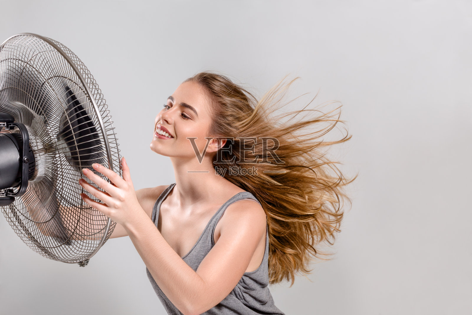 年轻女子用冷却器风扇照片摄影图片