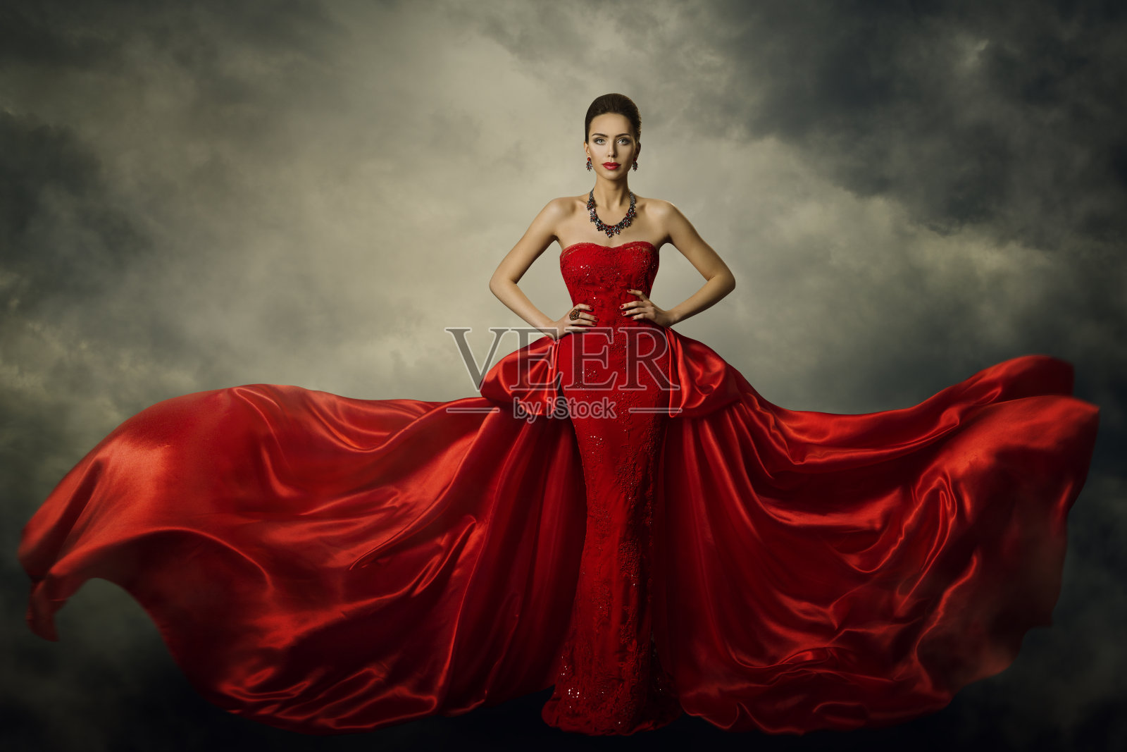 时装模特艺术礼服，优雅的女人在红色复古长袍，丝绸面料在风暴中飘扬照片摄影图片