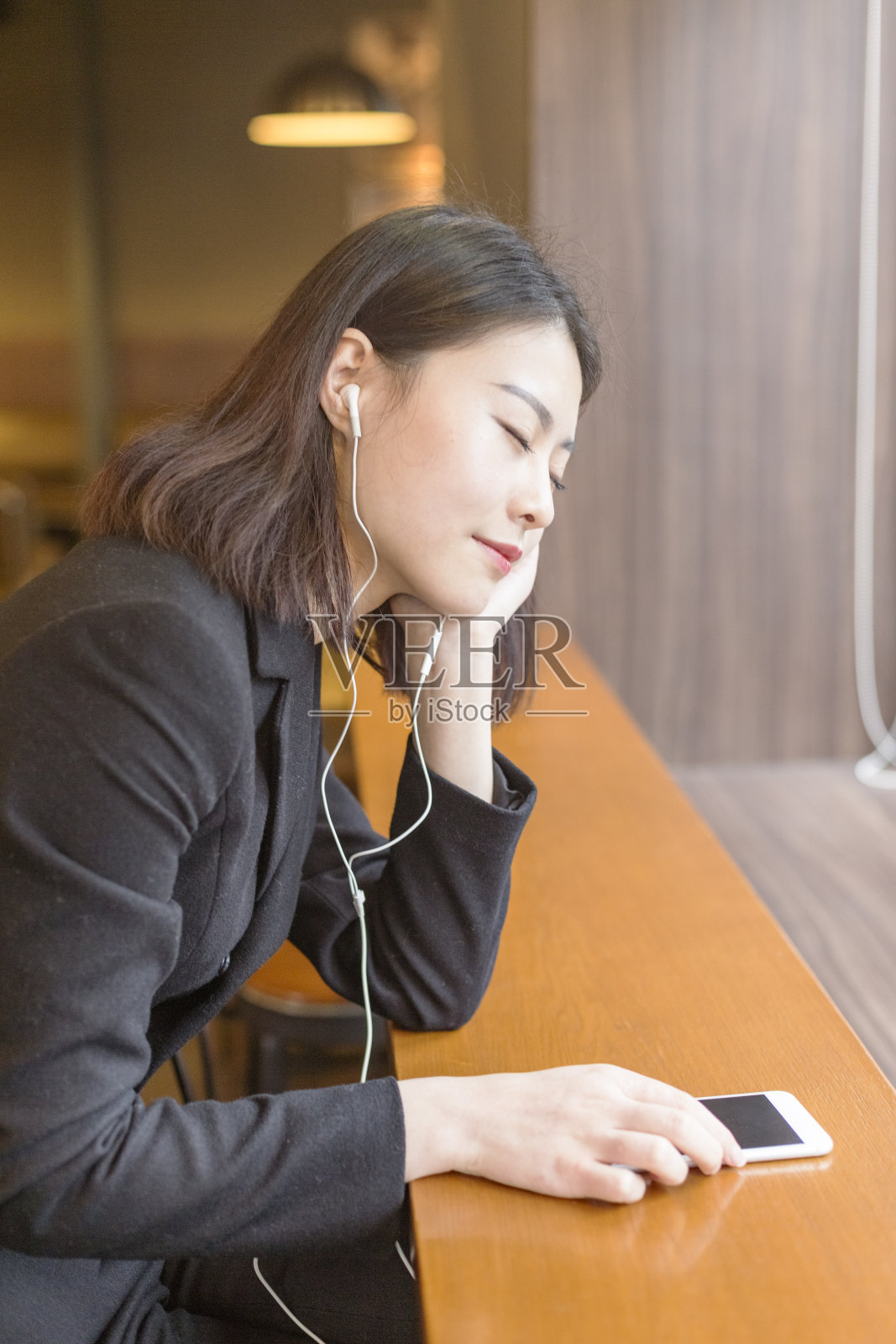 一个在咖啡馆听音乐的女人照片摄影图片