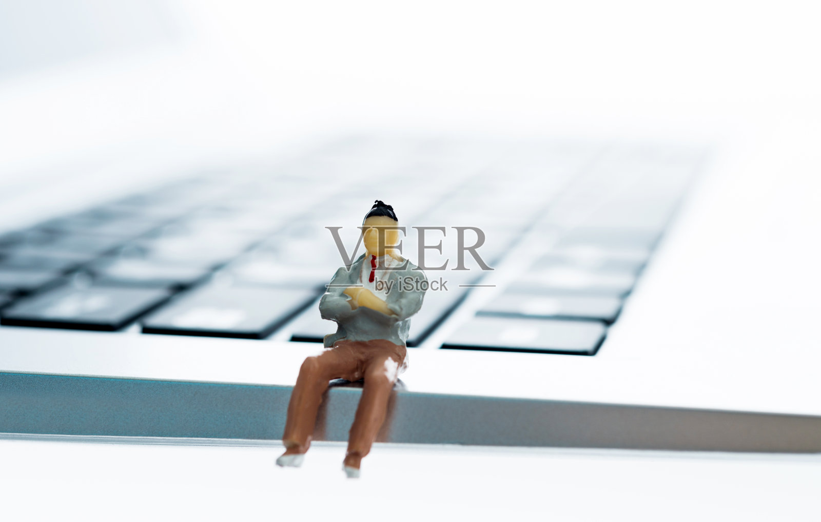 商人雕像坐在键盘上照片摄影图片