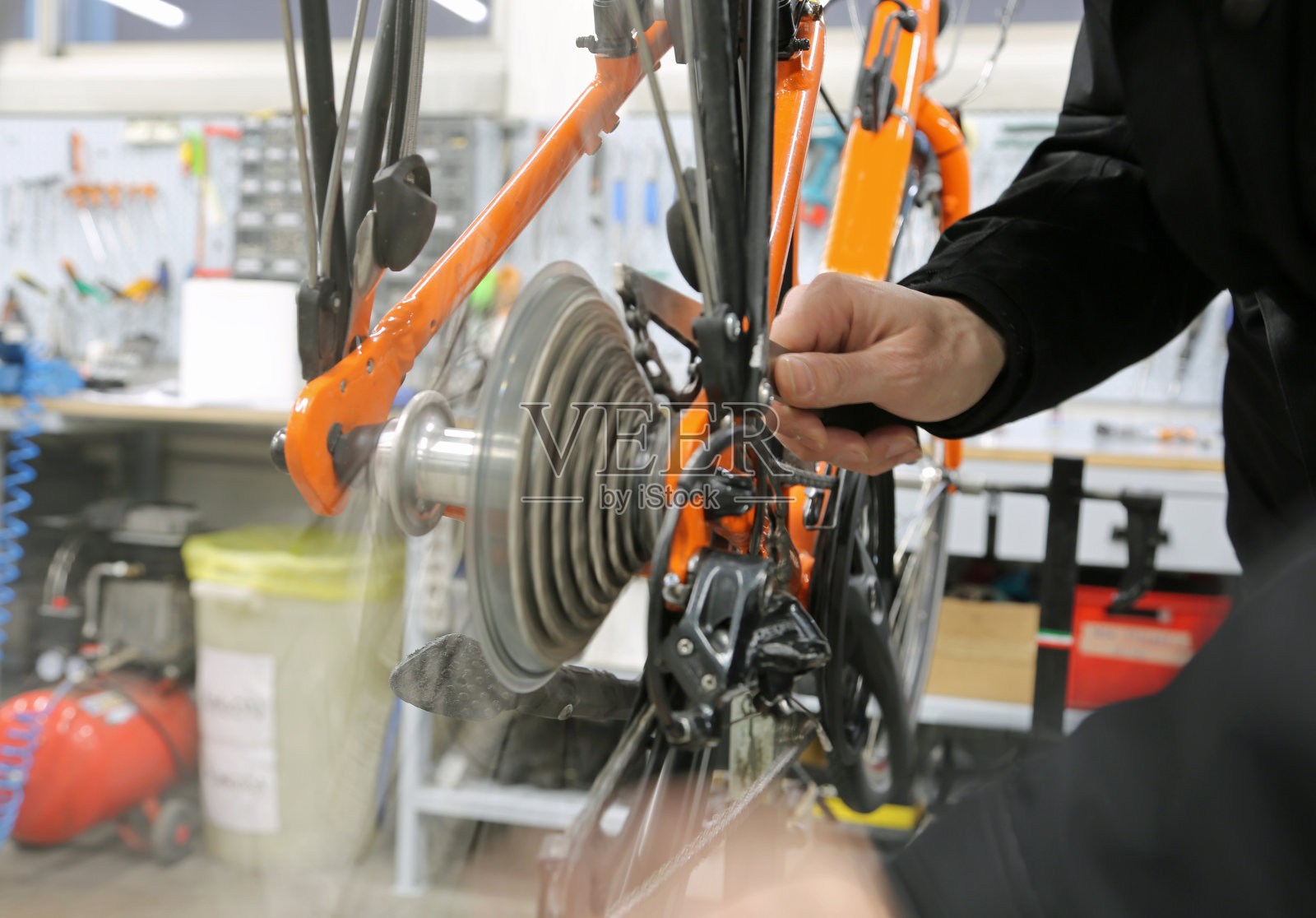 修理工在修理自行车的传动齿轮照片摄影图片