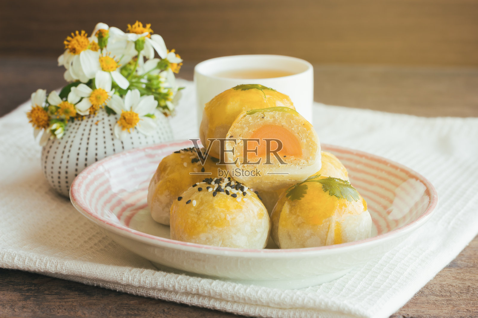 在侧面的木桌上放着美味的中式点心或月饼，里面包着绿豆沙和咸蛋黄。自制的面包店的概念。照片摄影图片