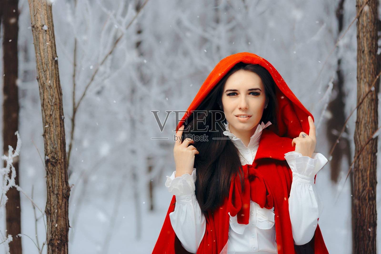 美丽的小红帽公主在魔法冬天的森林照片摄影图片