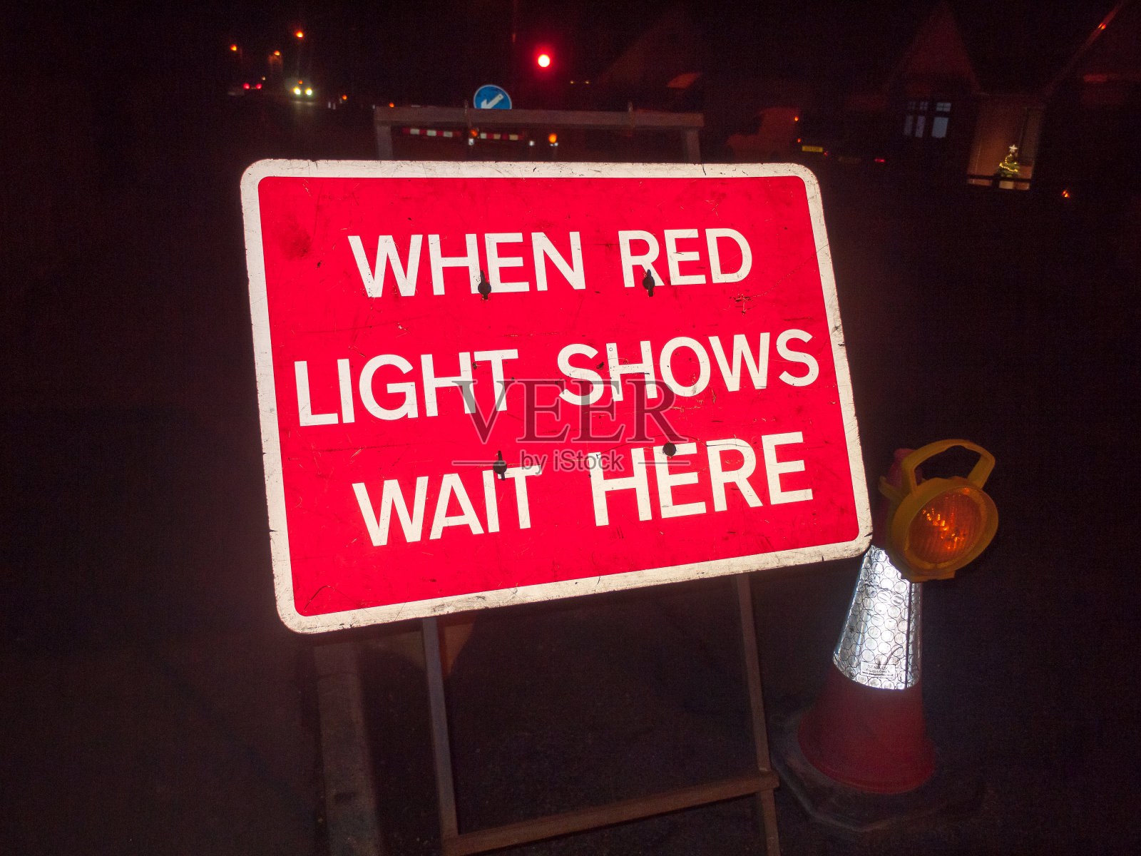 红色建筑标志在晚上的道路，当红灯显示在这里等红绿灯照片摄影图片