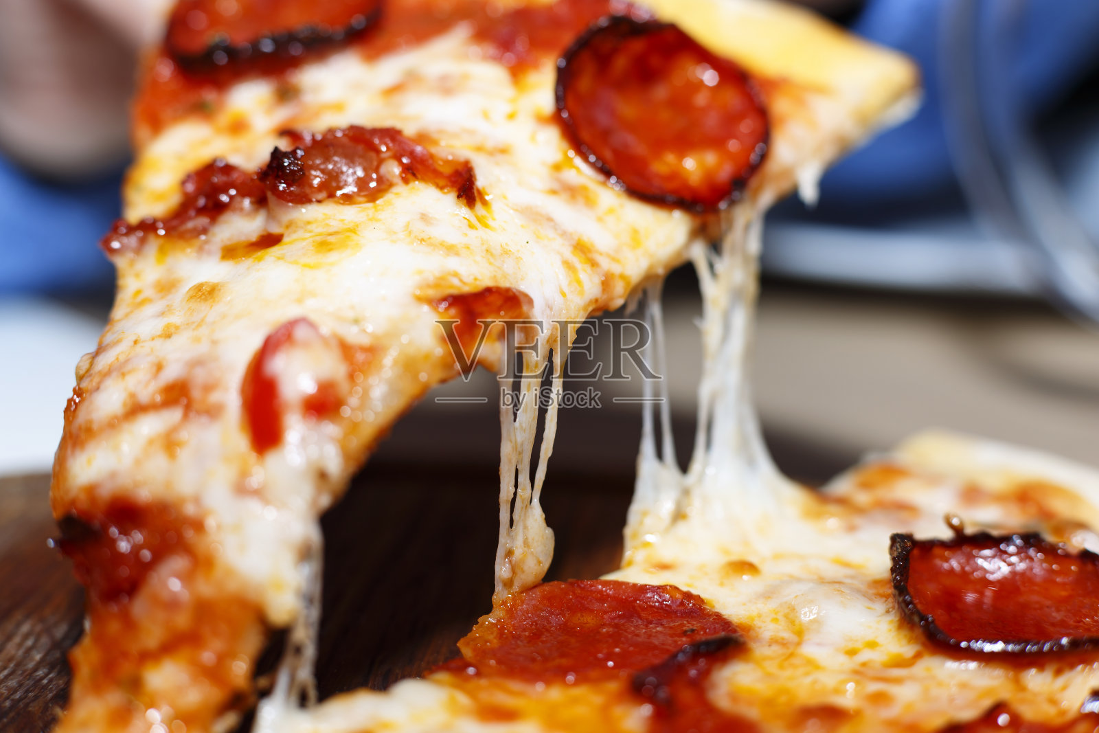 意大利辣香肠披萨-新鲜自制的披萨，配上意大利辣香肠，奶酪和番茄酱，配上质朴的木制背景材料照片摄影图片_ID:420061495-Veer图库
