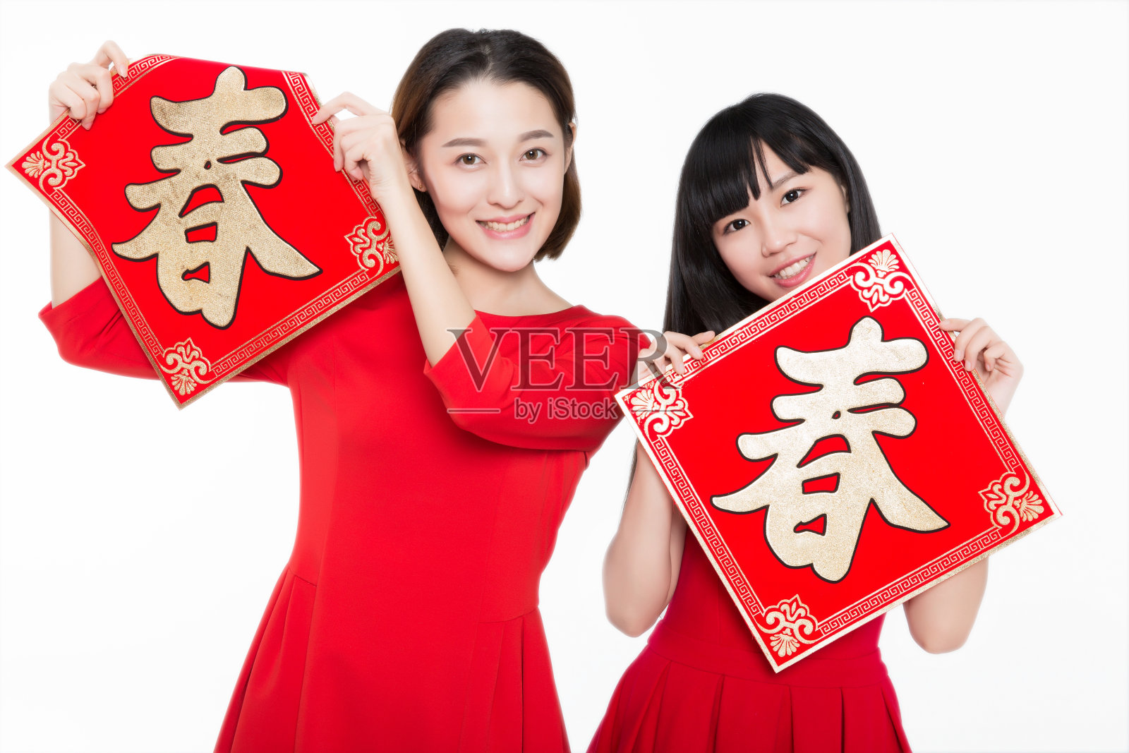 两个年轻的女人拿着中国对联，微笑着对着镜头照片摄影图片