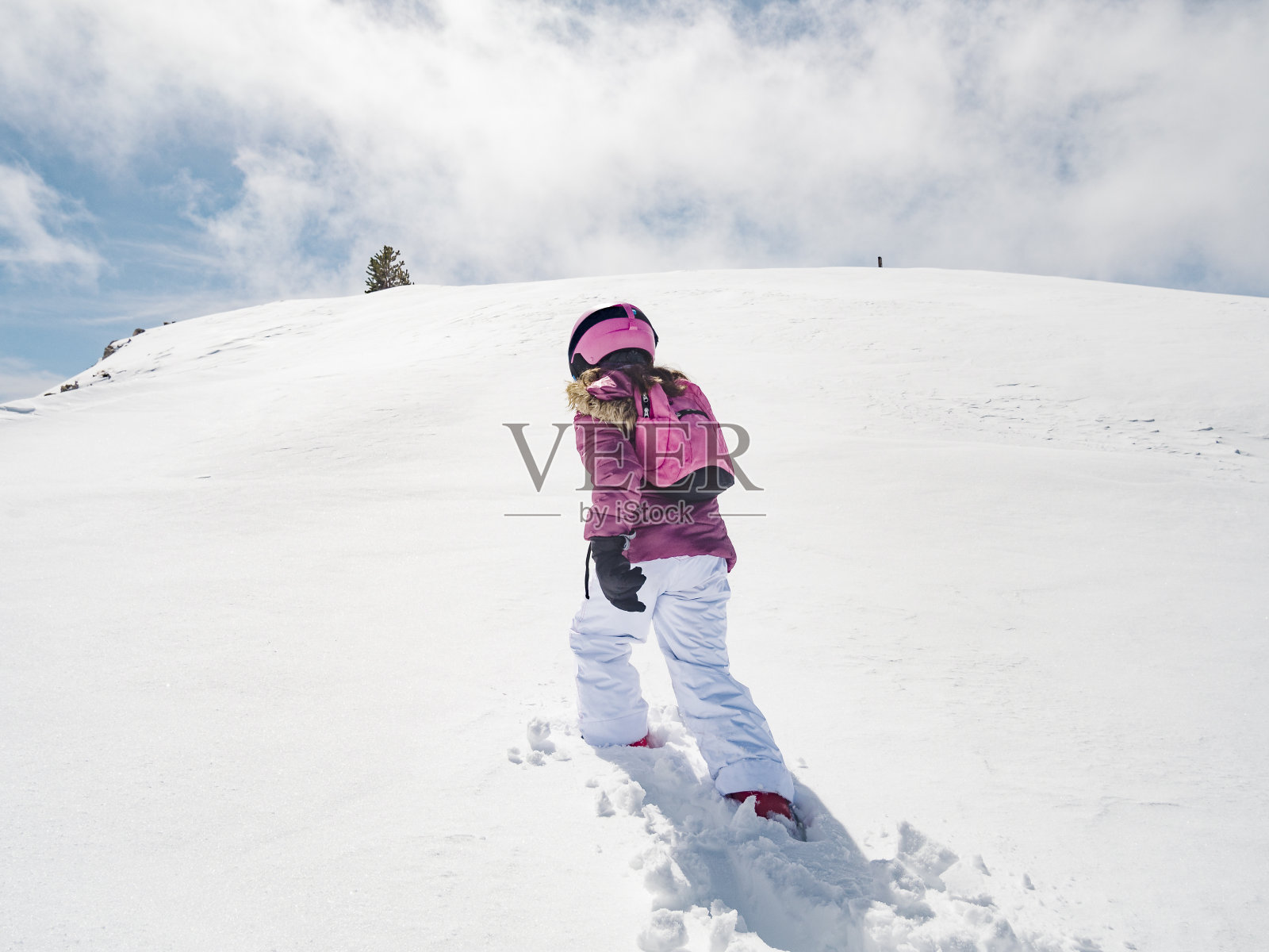 穿着滑雪服的女孩在雪地里行走照片摄影图片