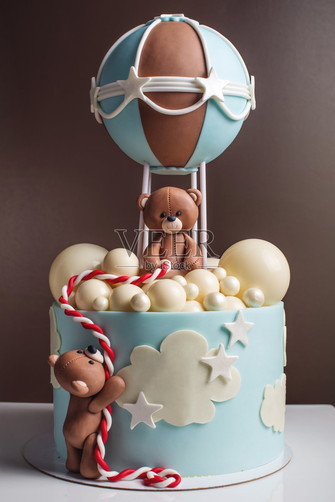 漂亮的装饰蛋糕为一个孩子。熊在气球里飞行。生日甜点的概念照片摄影图片