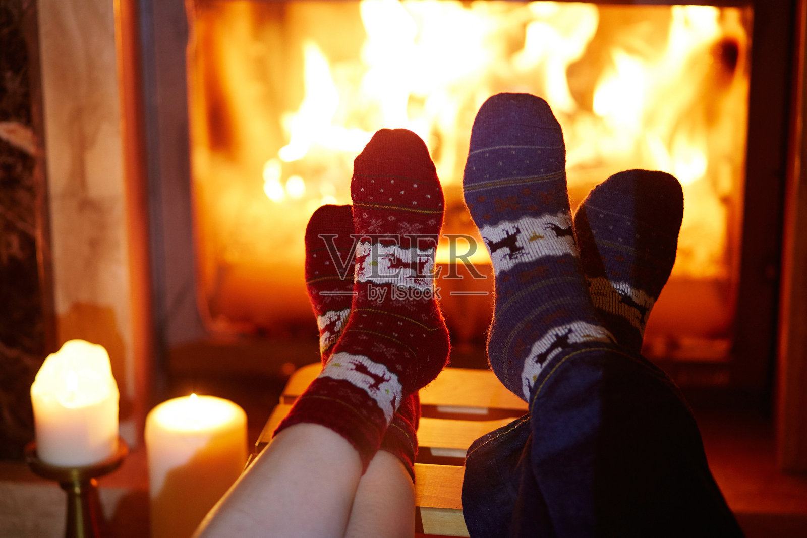 穿着暖和袜子的男人和女人在壁炉旁照片摄影图片