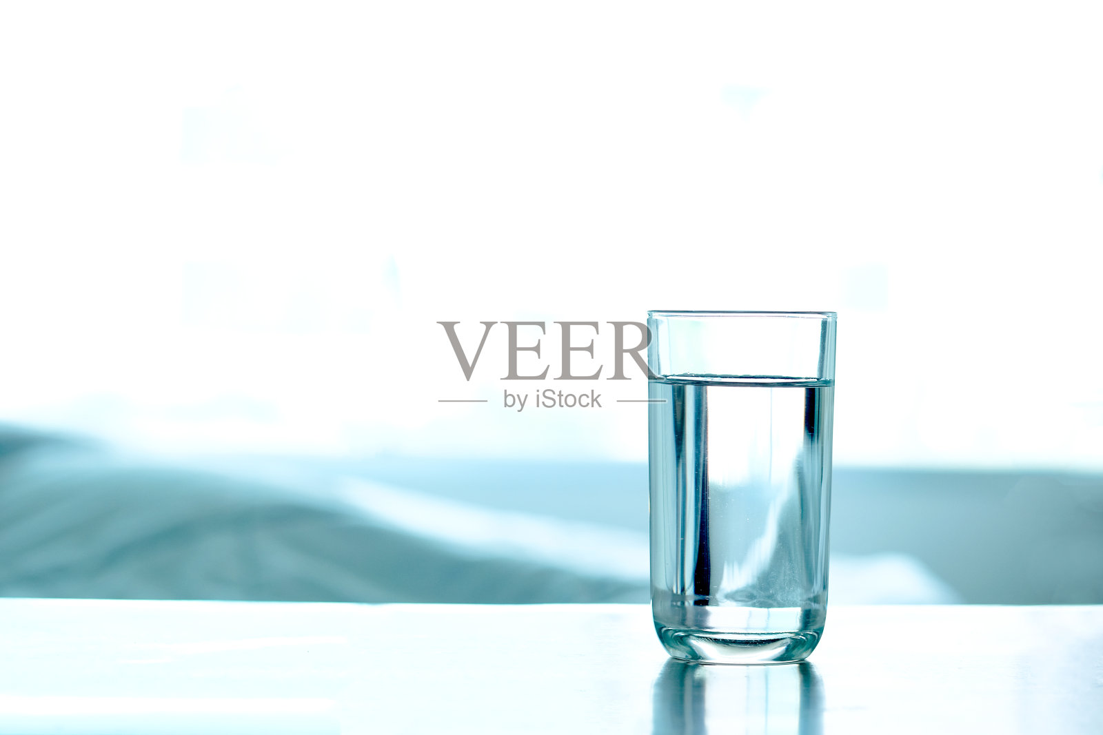 喝水。桌上的杯子里有纯净水。健康的概念照片摄影图片