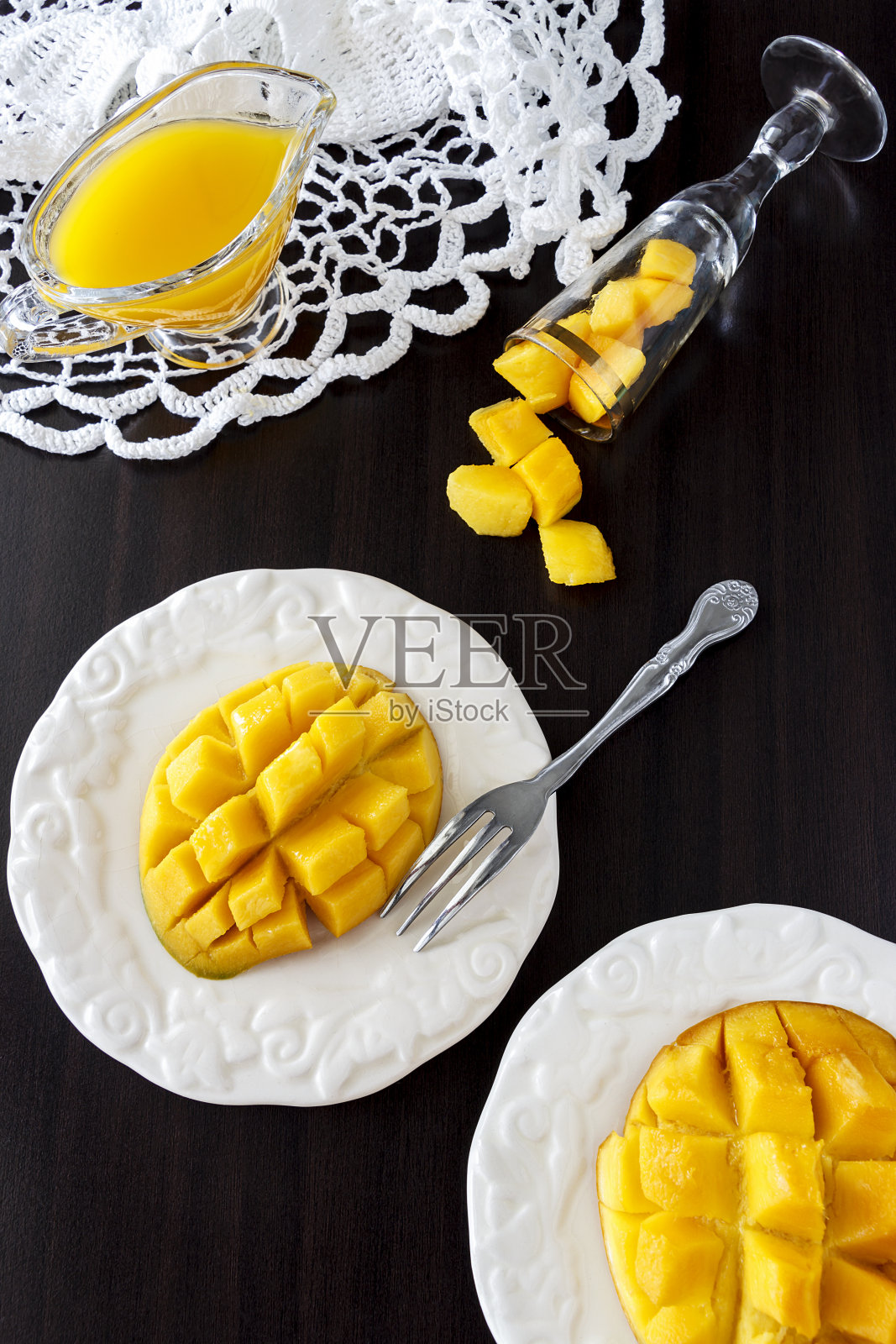 深色木质背景上的芒果果块和芒果汁泥。热带水果的概念。素食食品的概念。照片摄影图片