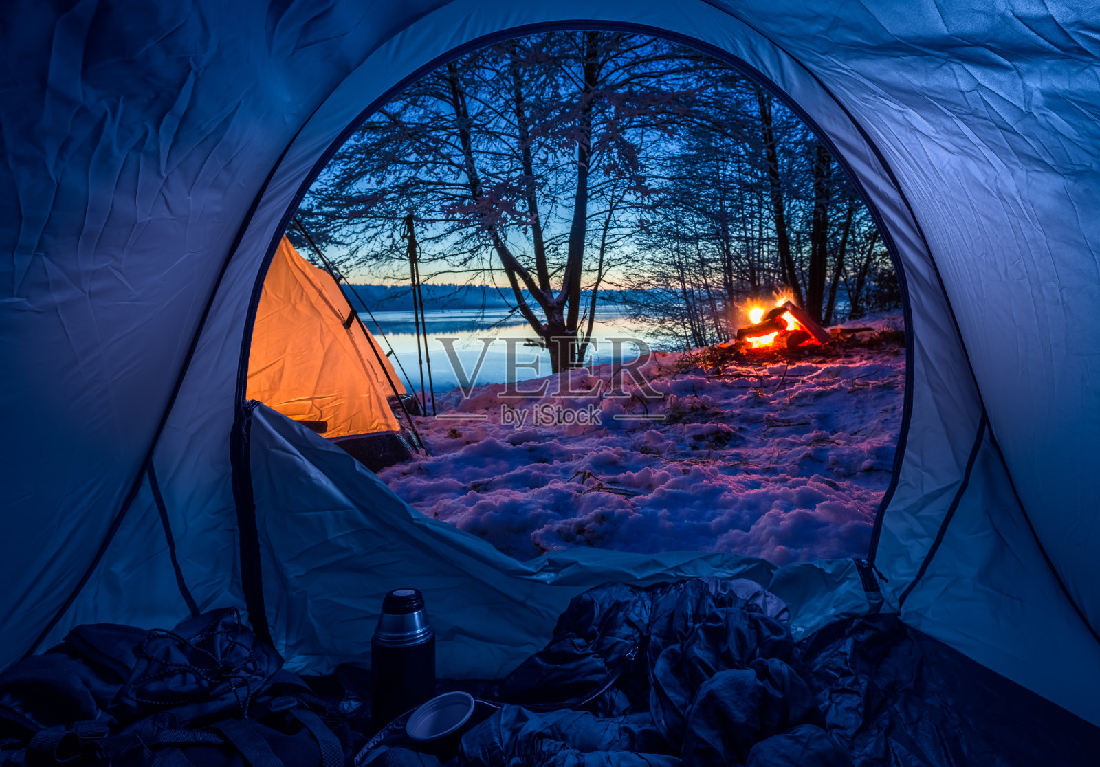 冬天黄昏时，在湖边用篝火宿营照片摄影图片