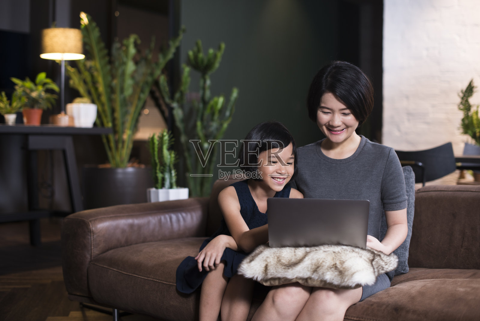 亚洲母亲和女儿看笔记本电脑照片摄影图片