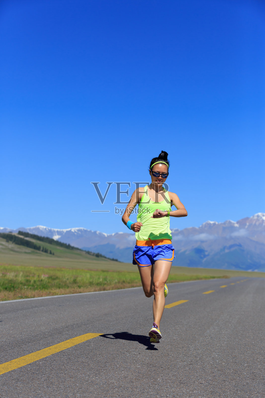年轻的健身健康的生活方式女性跑步者在路上与雪山在远方照片摄影图片