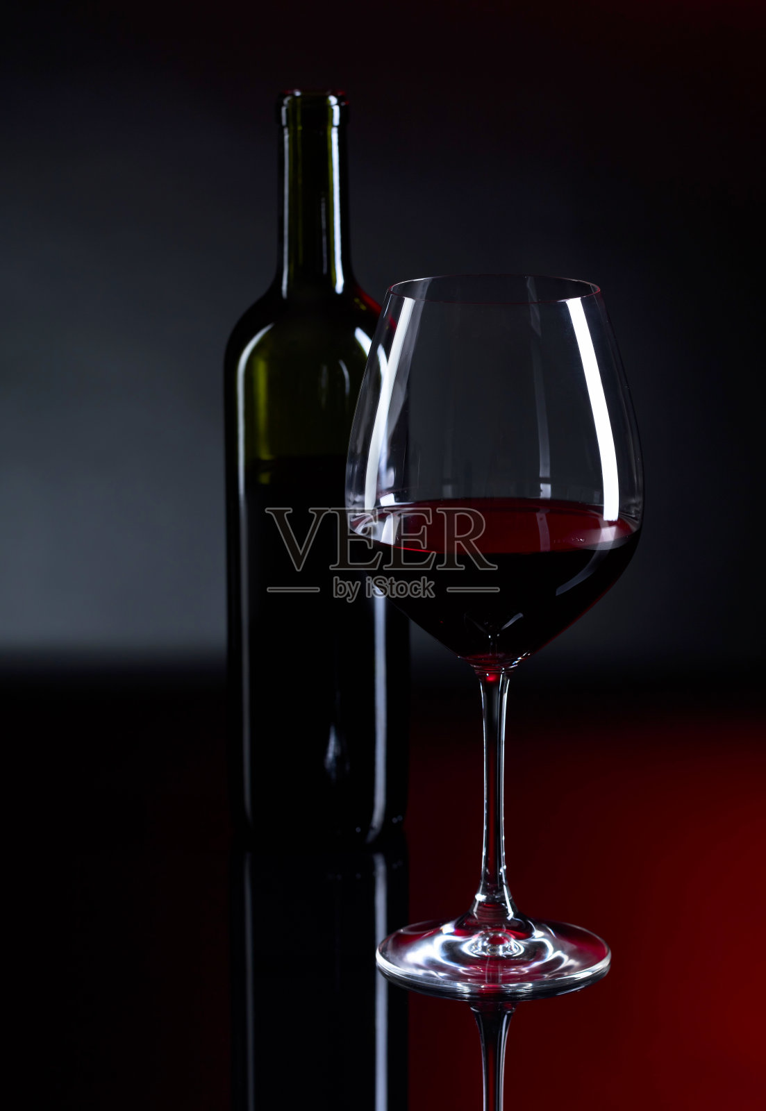 一杯和一瓶红酒。照片摄影图片