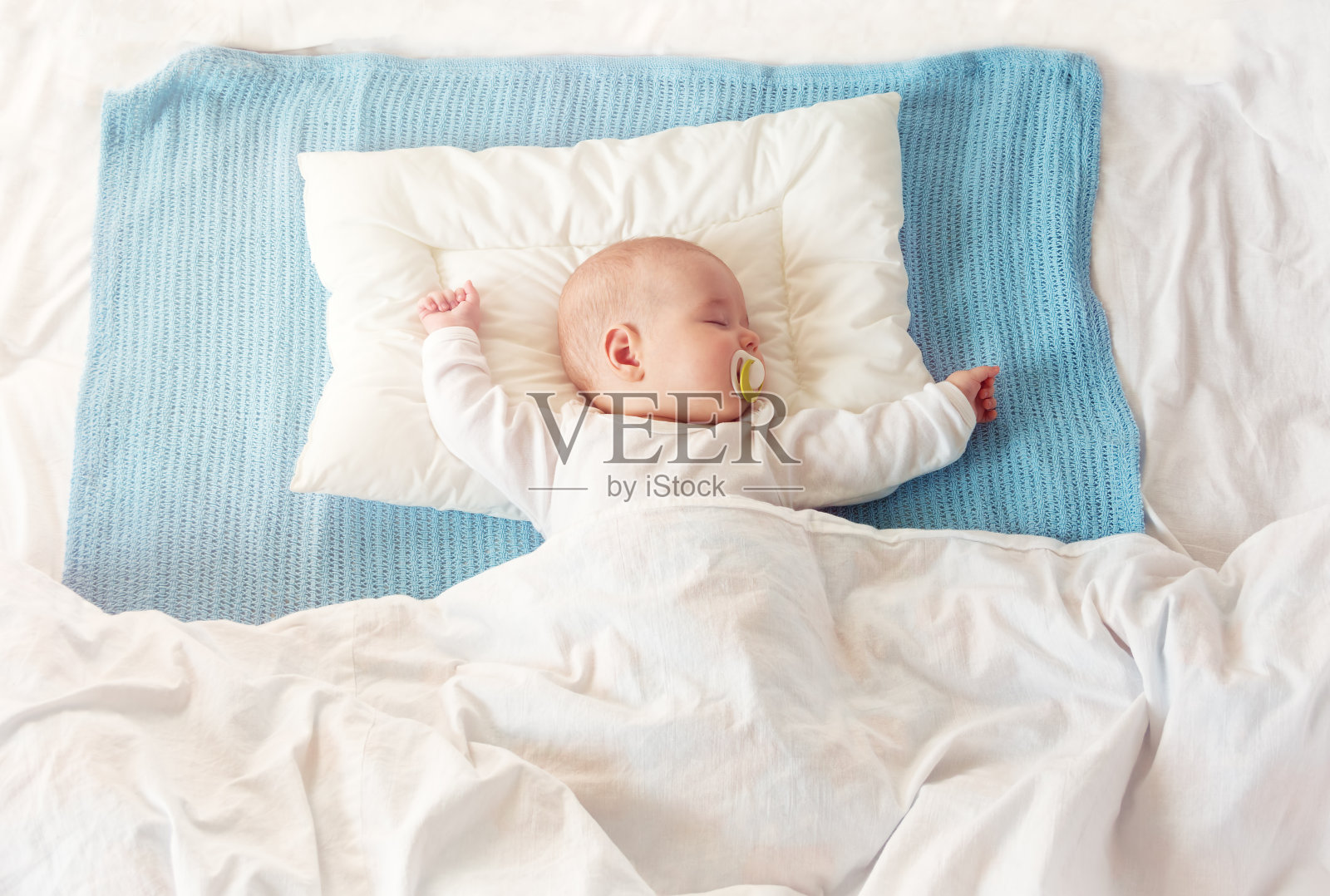 婴儿睡在蓝色的毯子上照片摄影图片