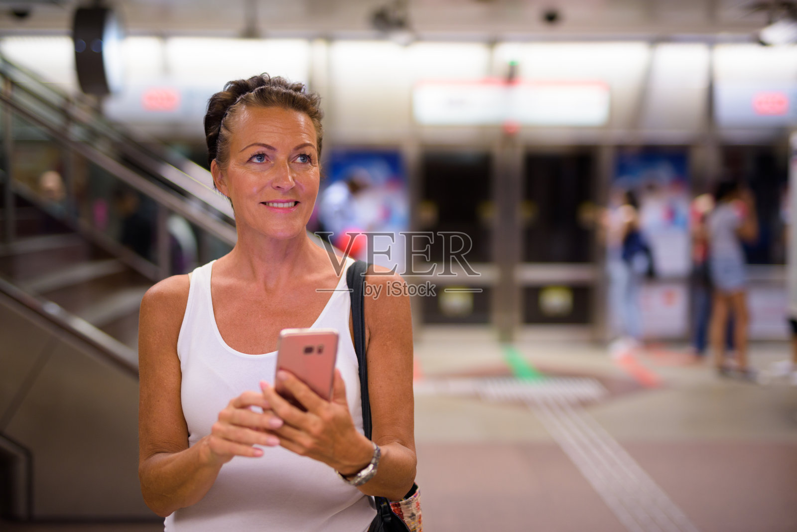 一名成熟女子在新加坡地铁站使用手机照片摄影图片