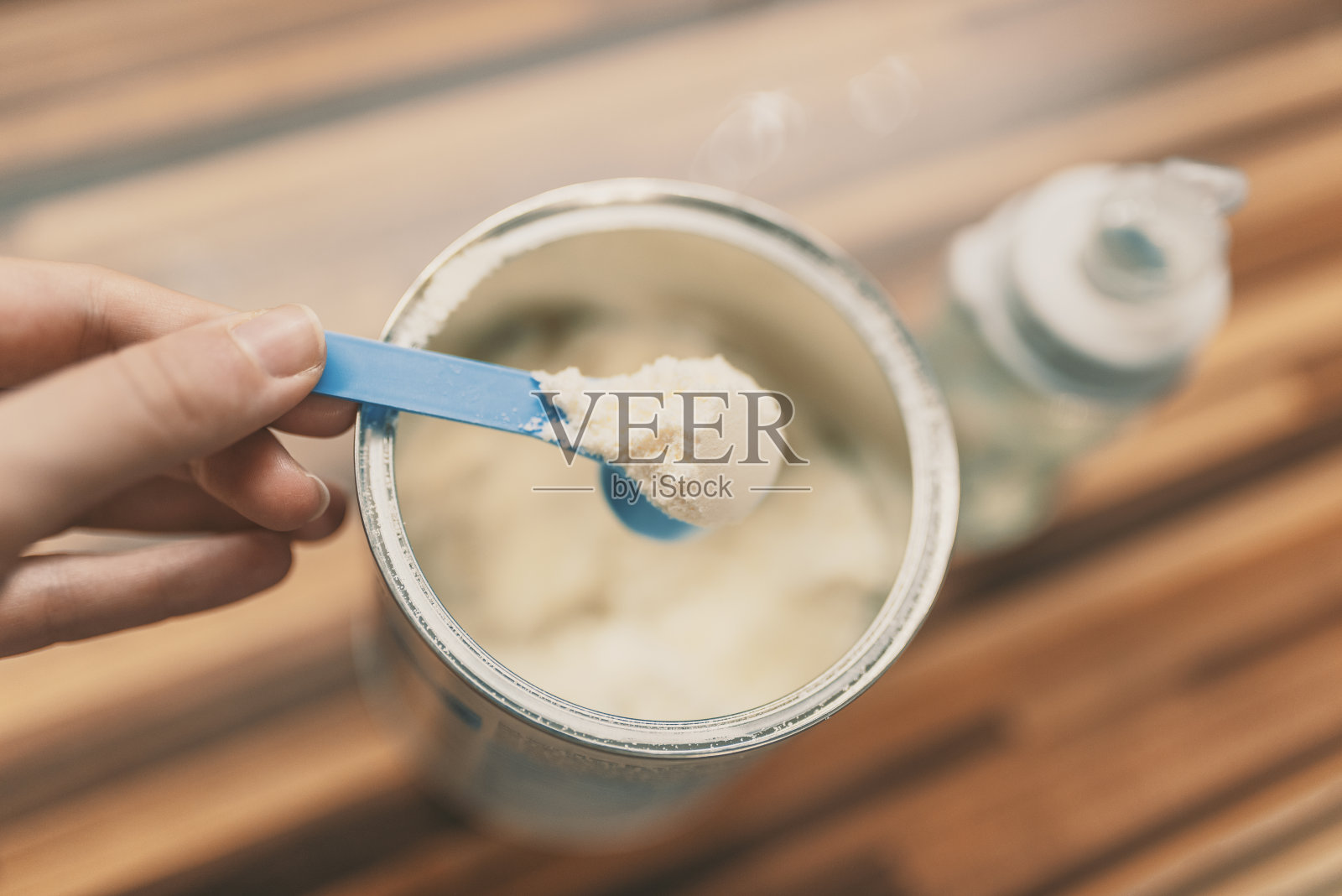 婴儿奶粉用量匙装在罐头上。照片摄影图片