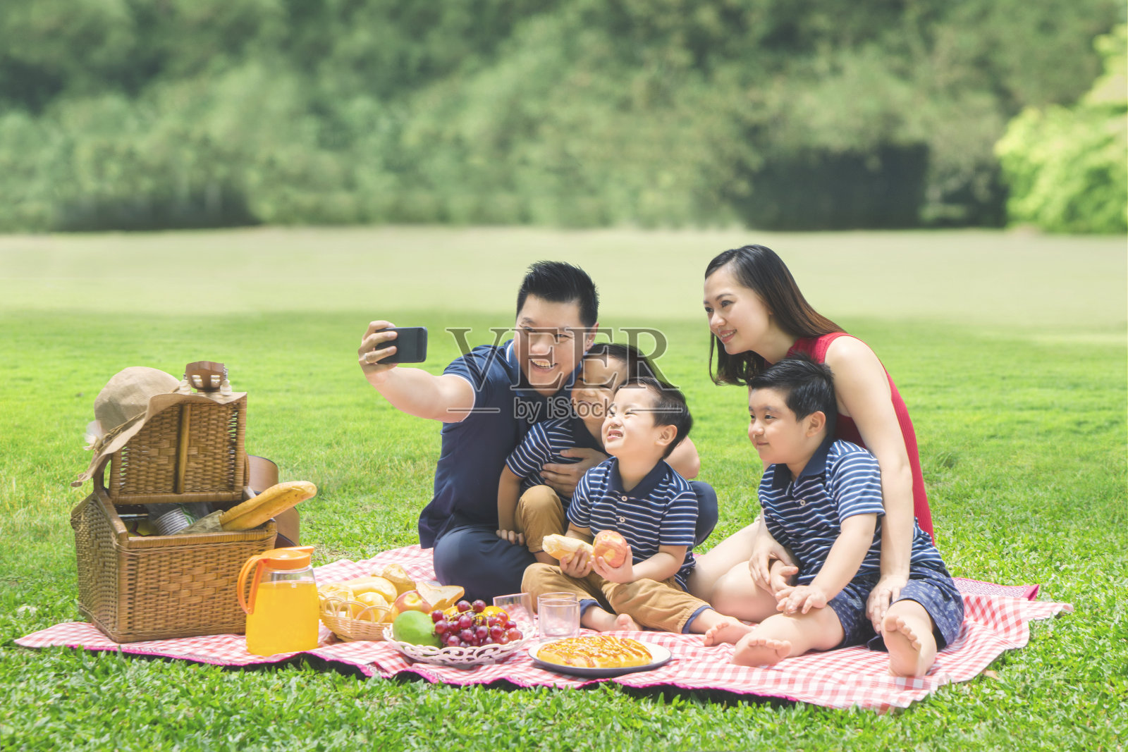 亚洲家庭在公园里拍照照片摄影图片