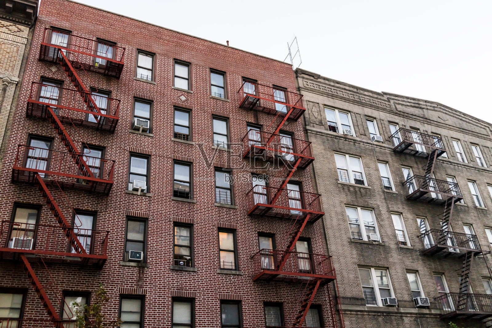 砖砌公寓共管大楼外部建筑Fordham Heights中心，布朗克斯，纽约市，曼哈顿，纽约市，有消防通道，窗户，空调在晚上照片摄影图片