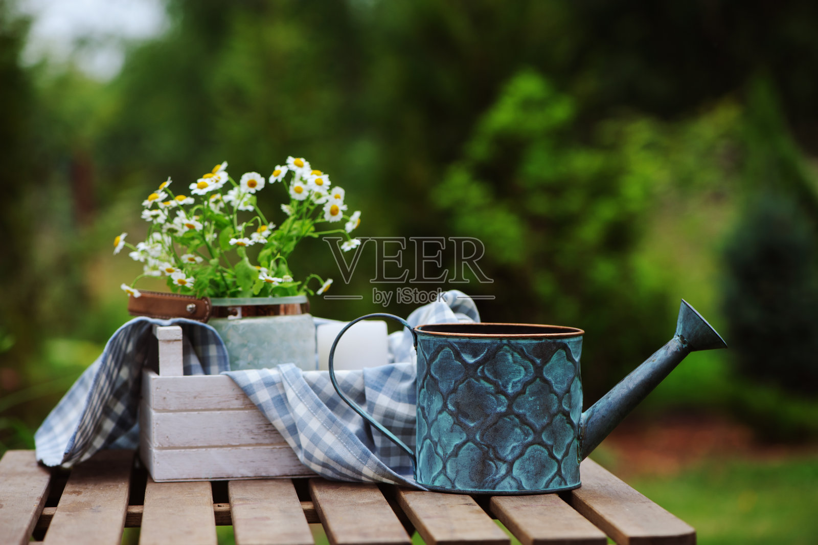 美丽的夏日景色，一束洋甘菊花，质朴的木托盘和绿色背景的桌布。花园的工作理念。照片摄影图片