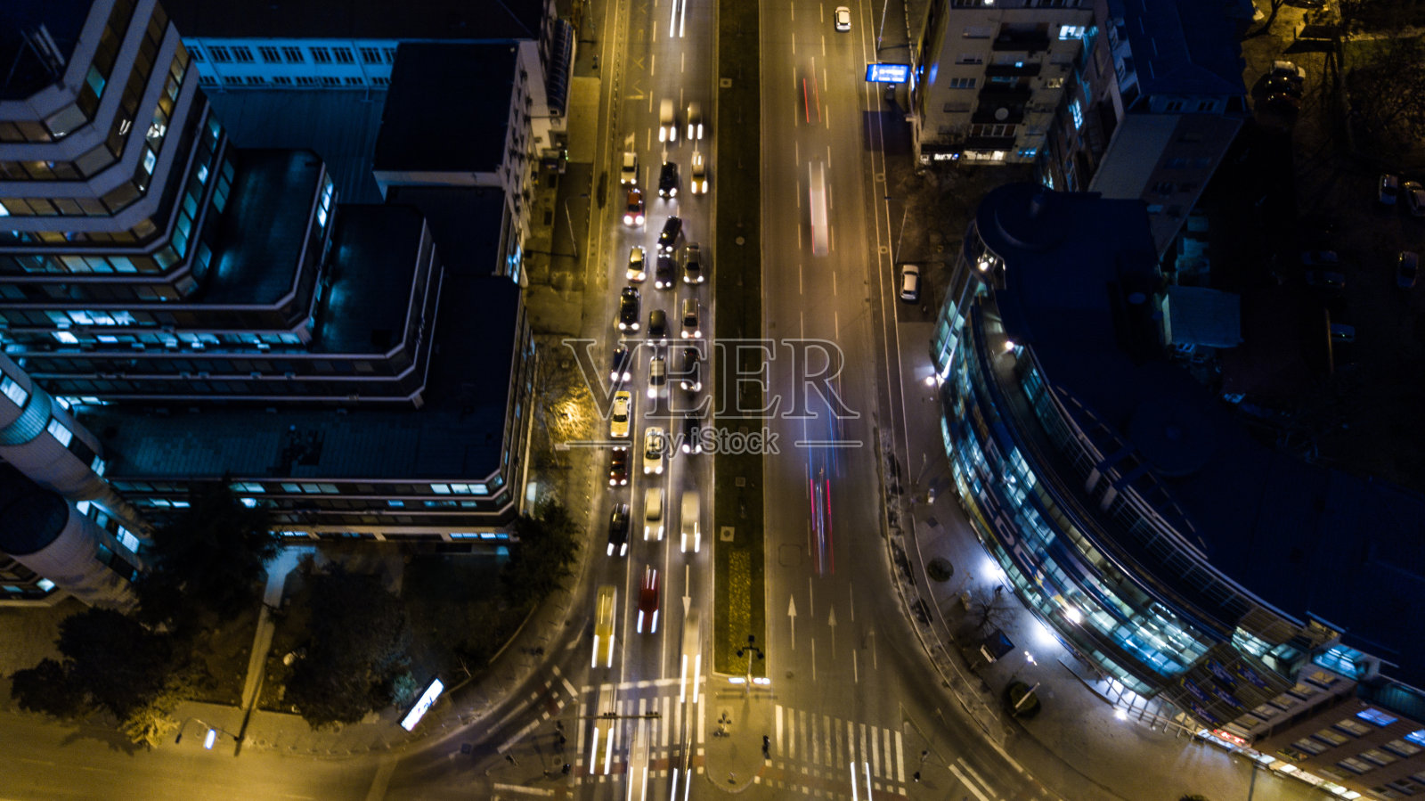 汽车在林荫大道上行驶的夜景鸟瞰图。无人机长曝光视图。建筑,建筑照片摄影图片