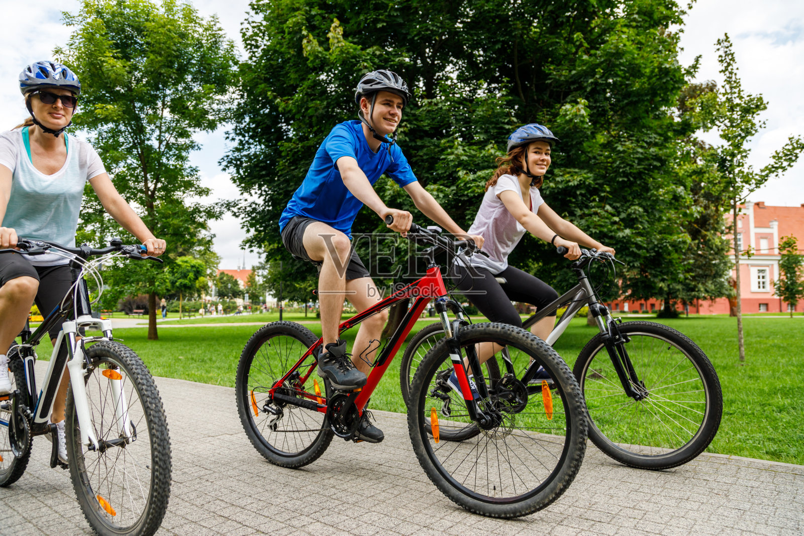 城市自行车——三个人在城市里骑自行车照片摄影图片