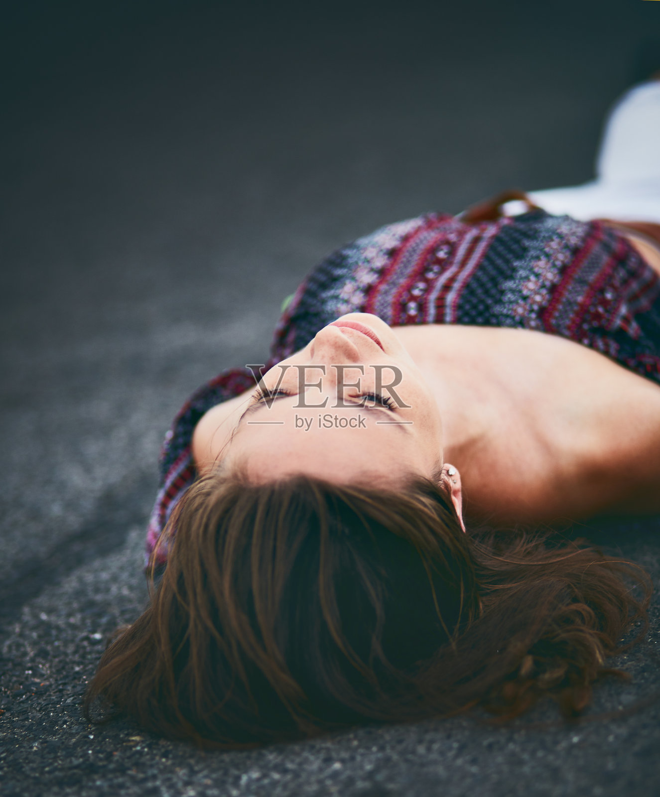 一个女人仰面躺在柏油路面上照片摄影图片