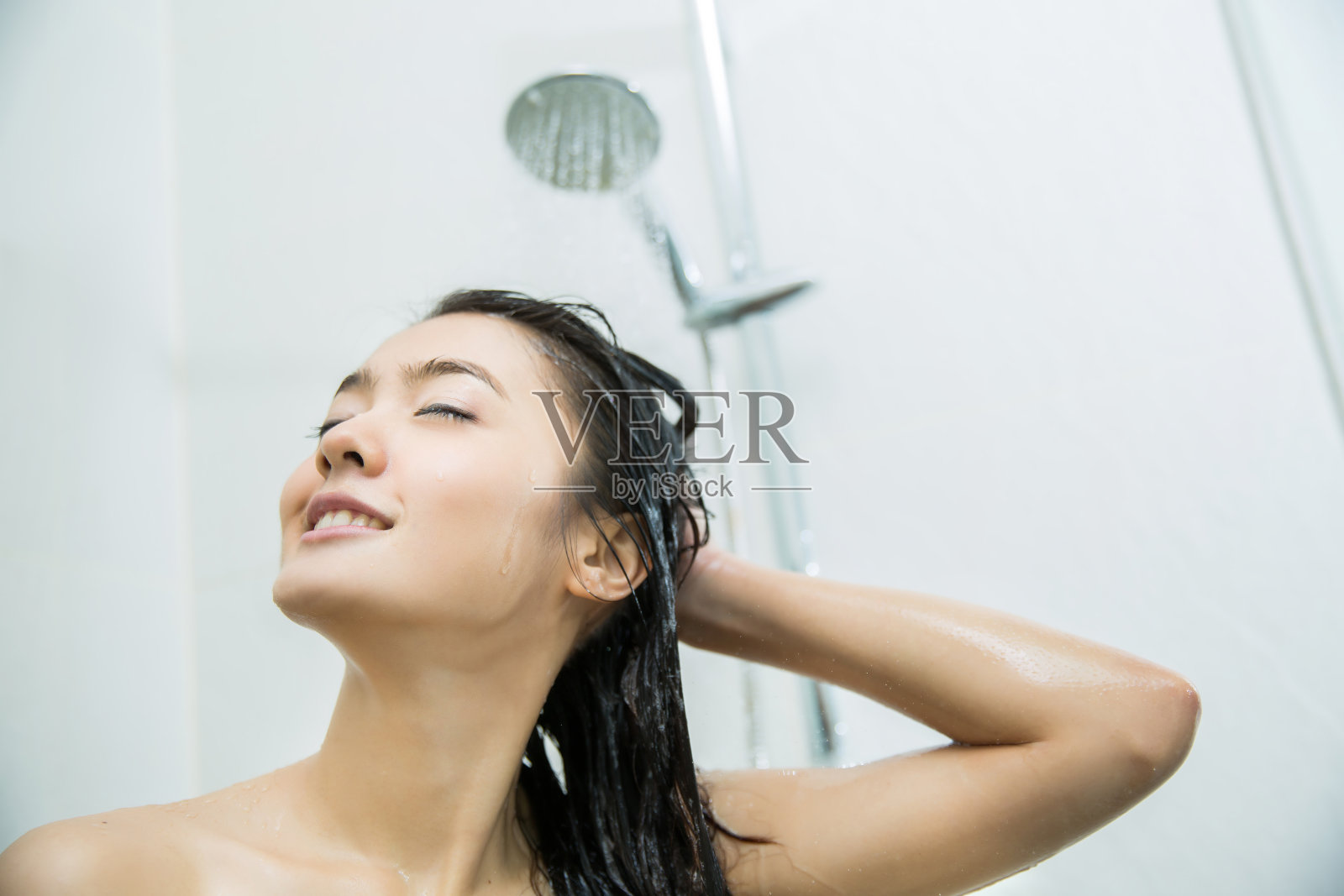 亚洲女人在洗澡，她很开心照片摄影图片