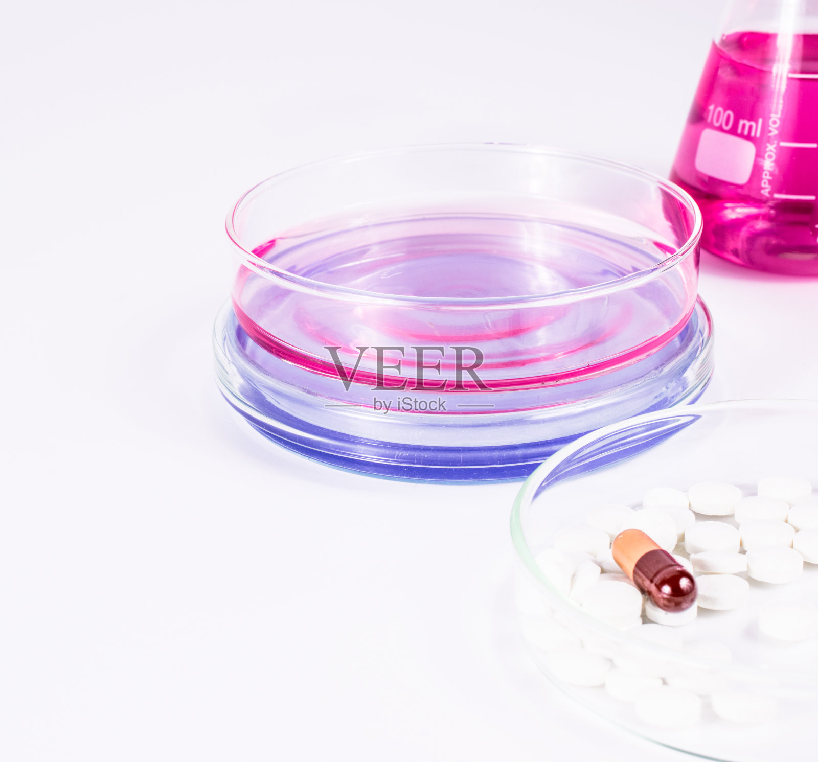 药物分析。皮氏培养皿中的药片和彩色液体。实验室，科学和临床背景。照片摄影图片