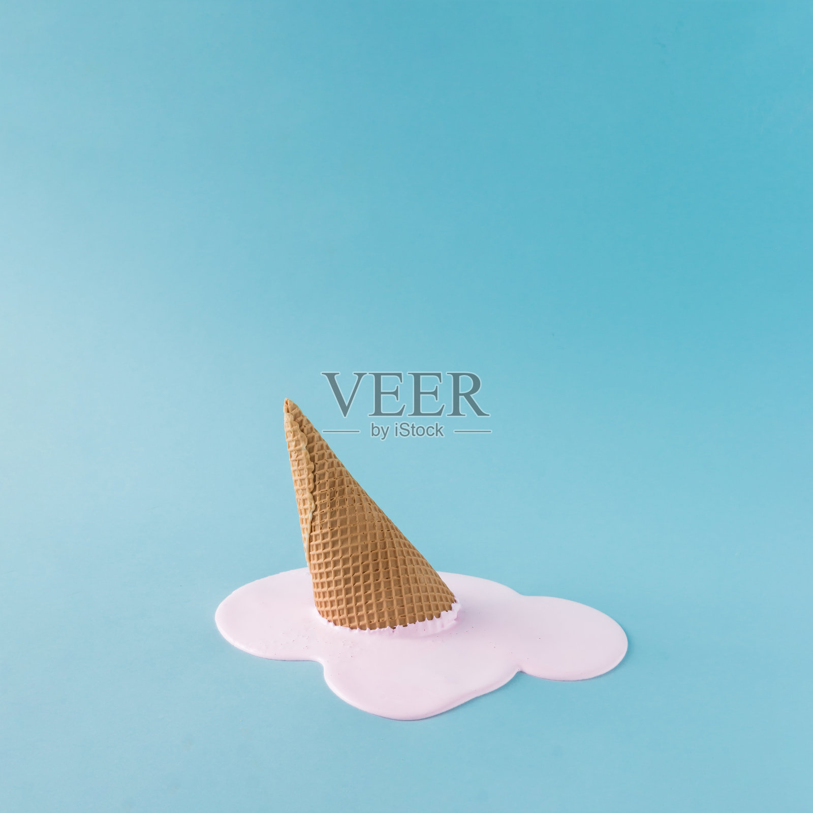 头顶上淡蓝色背景上的粉色冰淇淋。简约的夏季食物概念。照片摄影图片