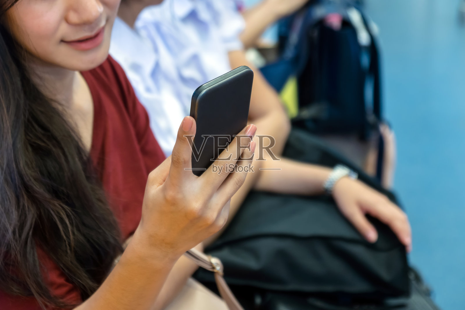 特写女性使用智能手机在BTS轻轨或捷运地铁在大城市旅行，生活方式和交通理念照片摄影图片