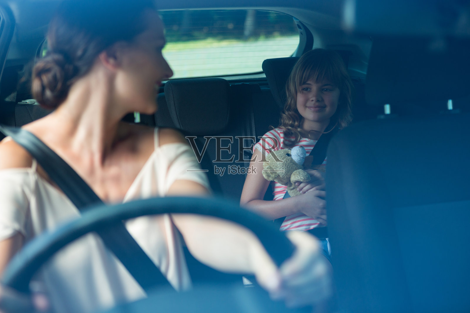 女人开车，女儿坐在后座上照片摄影图片