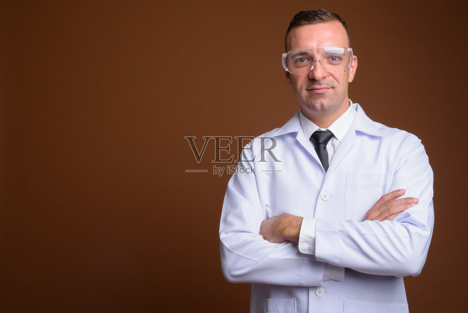摄影棚拍摄的男医生戴着保护眼镜，反对彩色背景照片摄影图片