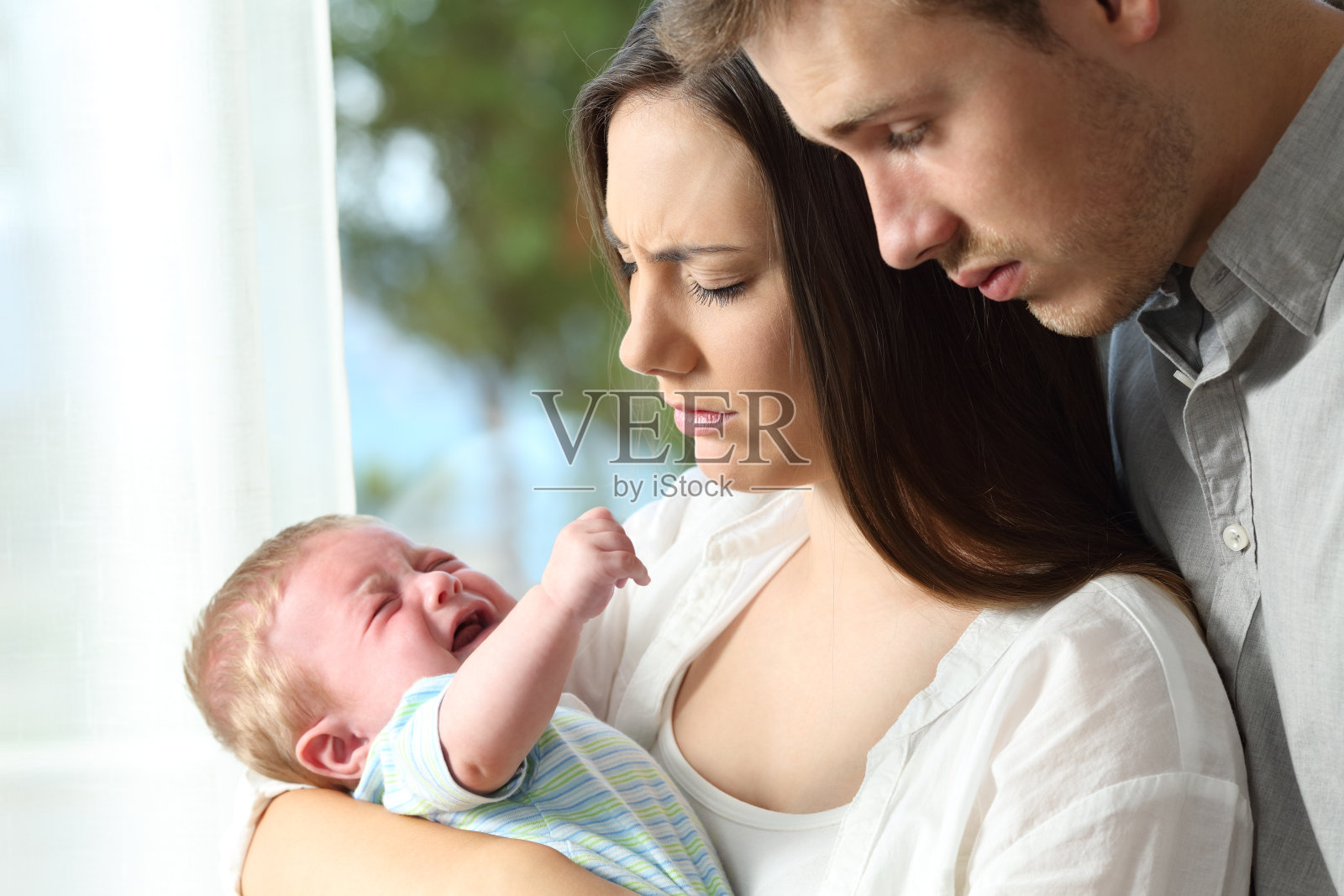 疲惫绝望的父母和哭闹的婴儿照片摄影图片