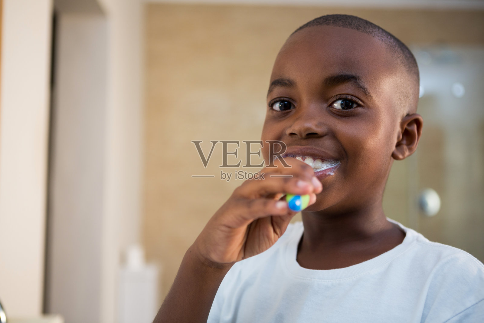近距离的肖像微笑的男孩与牙刷照片摄影图片